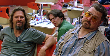 Three men sitting in a bowling alley.