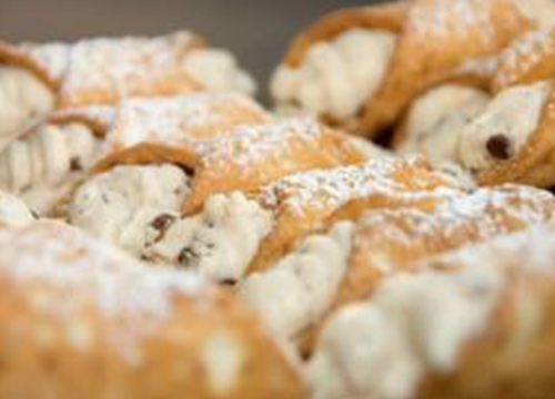 A plate of pastries with powdered sugar on it.