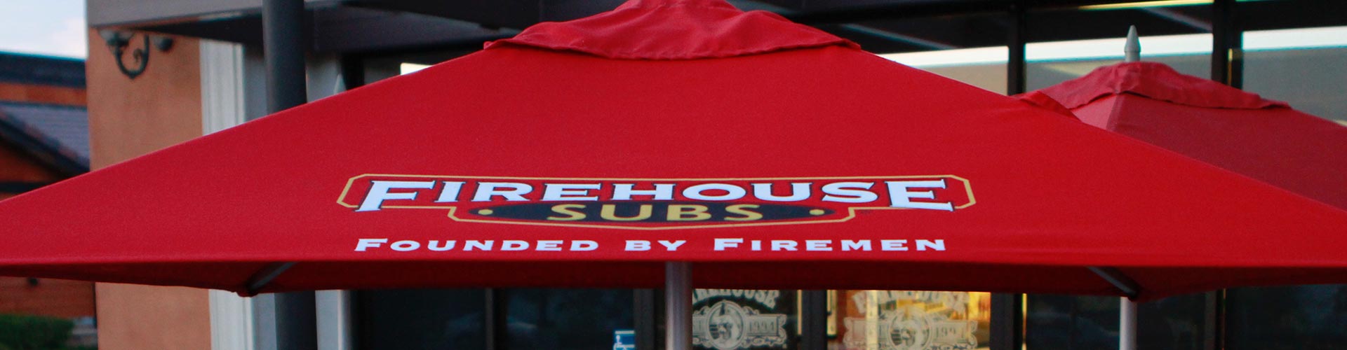 A red umbrella with the words firehouse subs on it.
