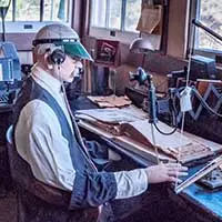 A man sitting at a desk in a radio room.