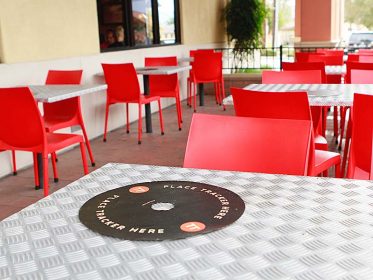 A table with red chairs and a disc on it.