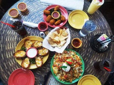 A table full of mexican food on a wooden table.